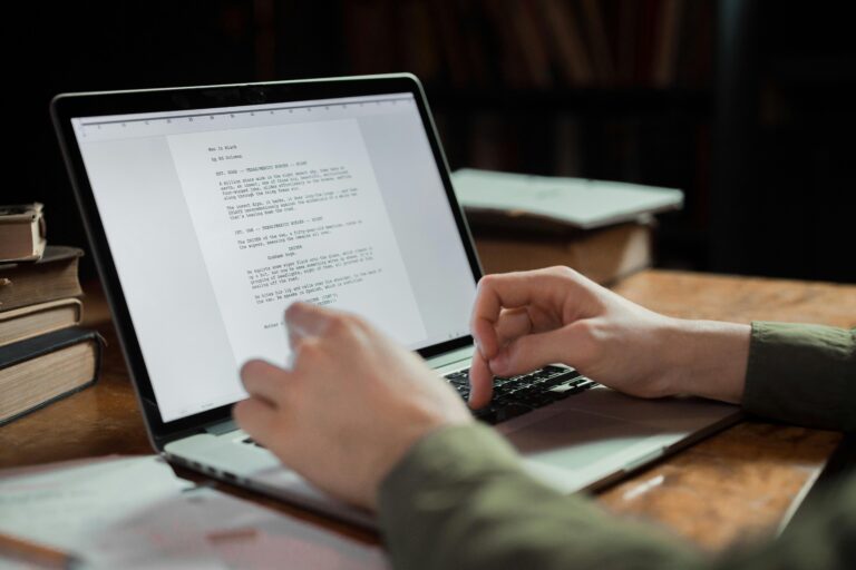 Una persona che scrive su un computer portatile e sta facendo l'editing di un libro